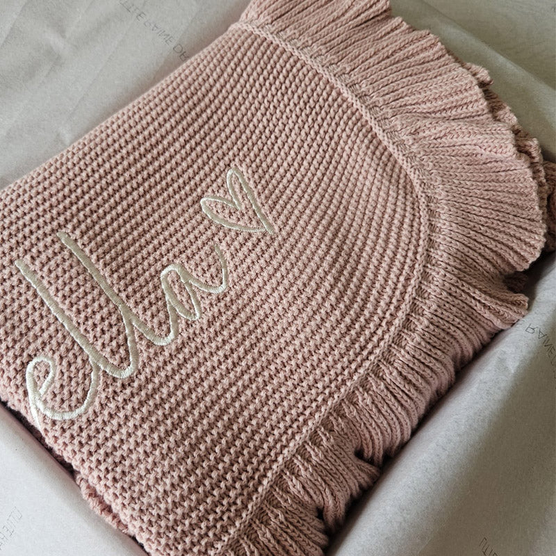 Personalised dusky pink scallop edge cotton knit baby blanket by Little Raine Drops, folded in gift-ready packaging. Baby blanket designed and personalised for newborns, baby showers, and timeless gifting