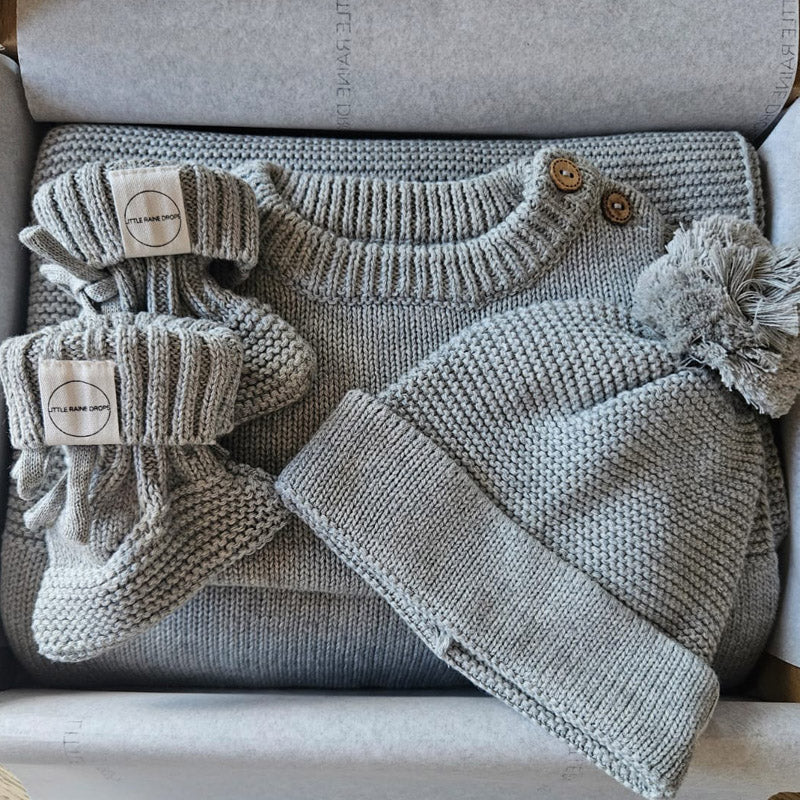 Grey chunky knit baby gift set including personalised romper, matching blanket, knit hat and booties, presented in a luxury gift box by Little Raine Drops.