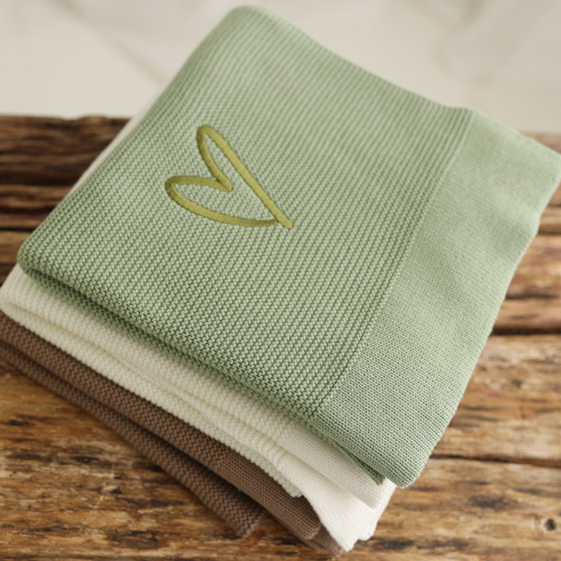 Stack of sage green, taupe and pearl cotton knit personalised baby blankets with embroidered heart detail, neutral personalised baby blankets by Little Raine Drops