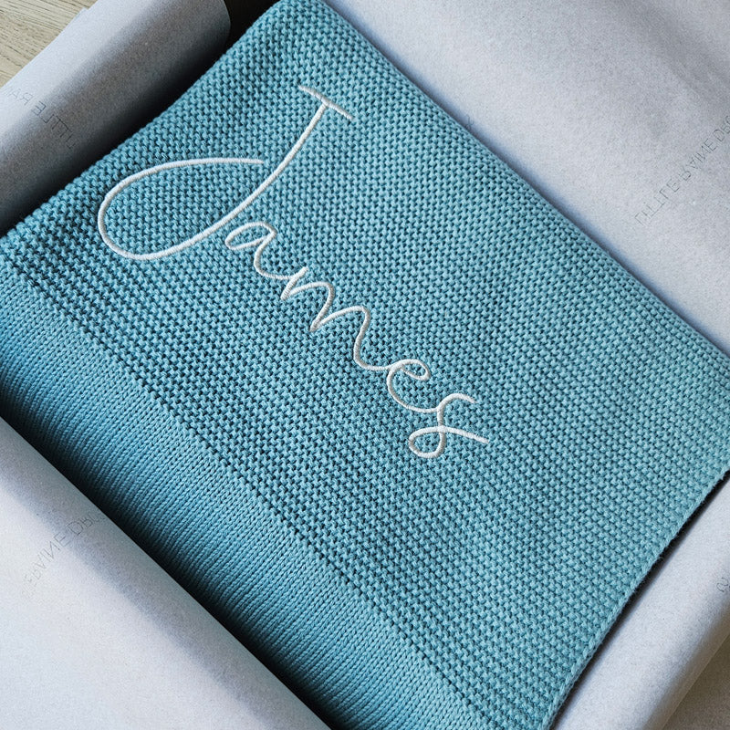 Teal cotton knit personalised baby blanket, folded and packaged. Personalised with the name James by little Raine Drops Ireland for beautiful soft keepsake, gift, baby shower gift