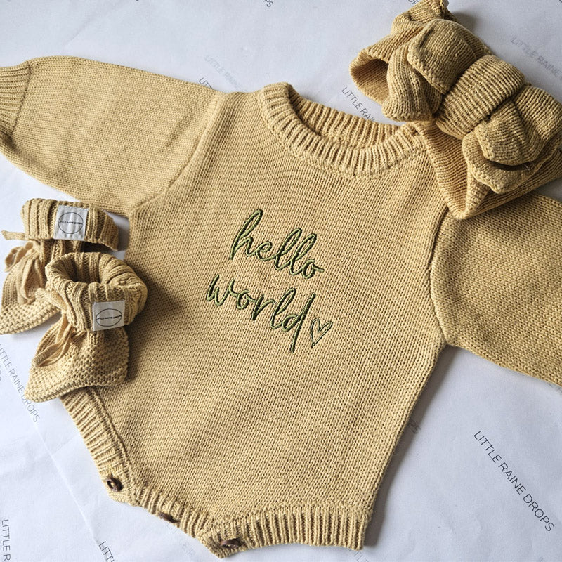 Ochre knitted baby announcement romper set embroidered with hello world styled flat by Little Raine Drops