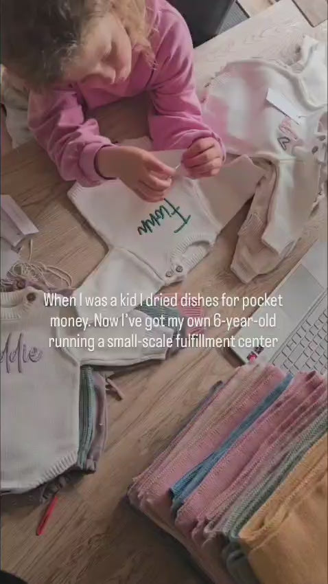 Callie Raine busy in the office folding and packing Little Raine Drops personalised blankets, chunk knit sweaters and other products for customers orders